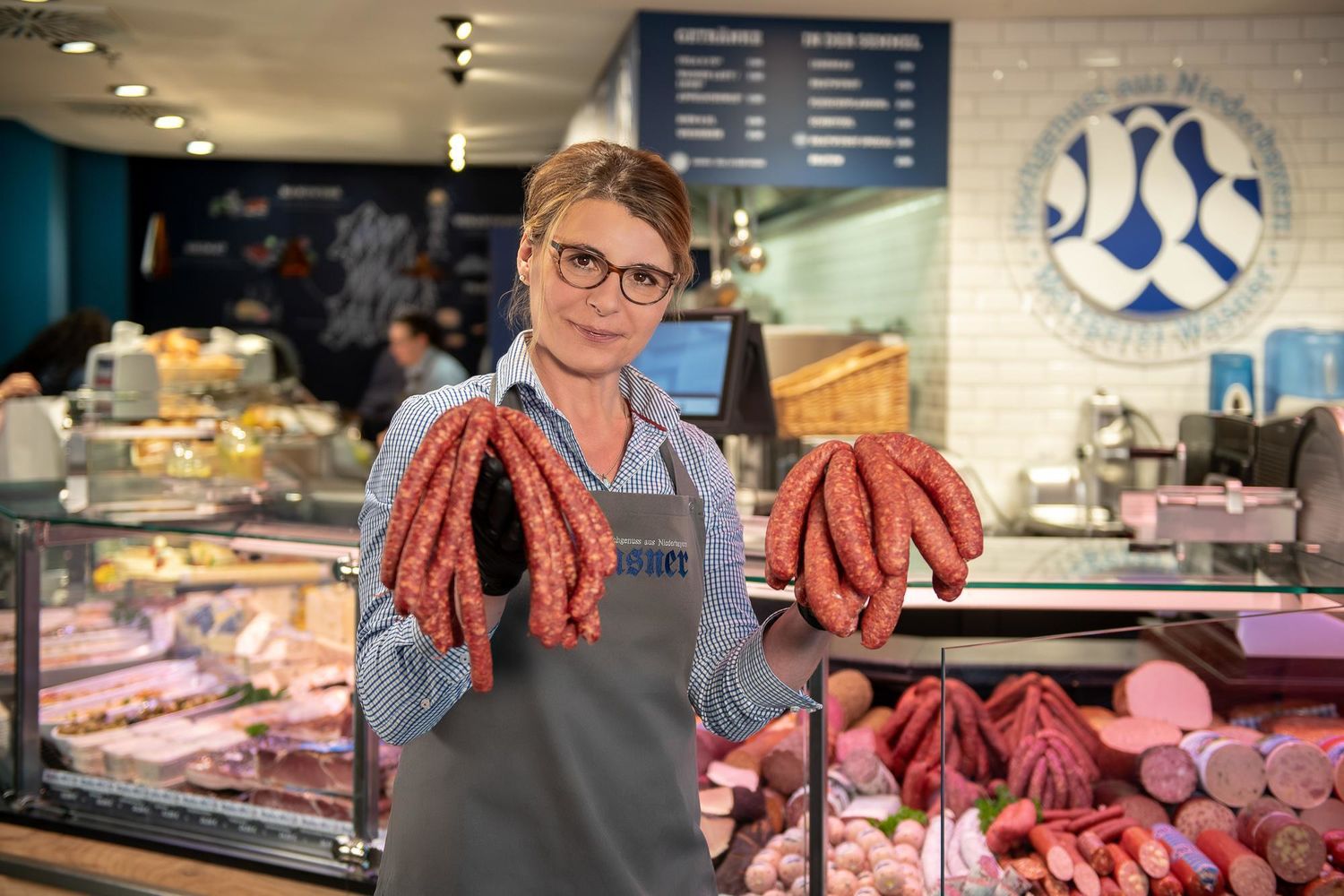 Eine Wasner Mitarbeiterin präsentiert Wurst